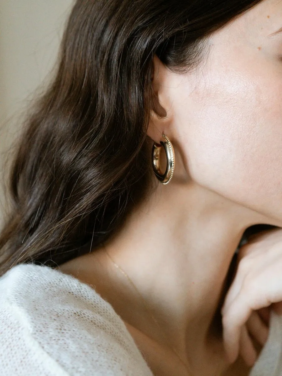 Hals med elegant gulløredobb – feminint og varmt.